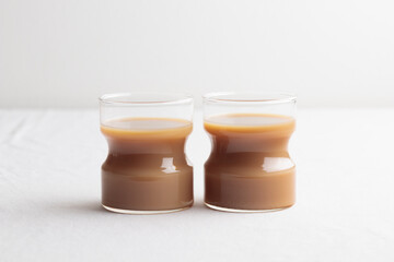 Cups of fresh coffee with milk on white table