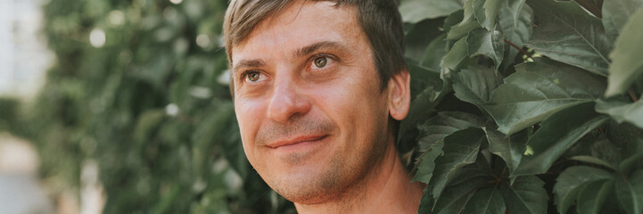 portrait of face happy smiling unshaven mature 40+ years man solo traveler with stubble and brown...