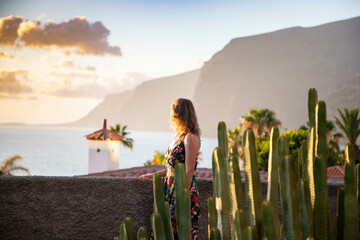 Frau, die den Sonnenuntergang über dem Meer auf den Kanarischen Inseln von Teneriffa betrachtet
