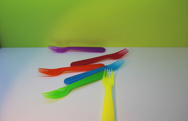 Obraz na płótnie Canvas multicolored forks on a white and green background