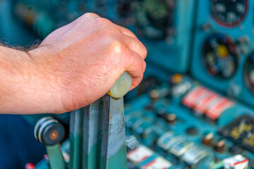 The captain's hand in selective focus  pressing the gas lever in the cockpit of the jet aircraft...