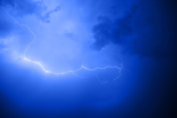 Dark cloudy sky with blue lightning