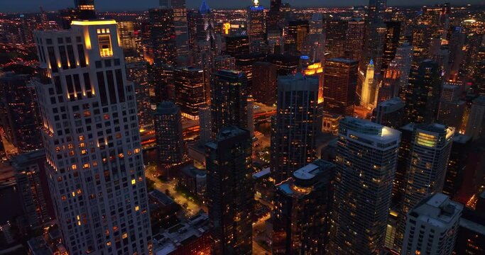 Contemporary architecture of stunning Chicago at night. Drone footage descending among beautiful skyscrapers.