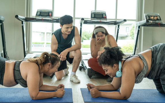 Two Overweight Girls Plank To Compete With Each Other And Have A Trainer And Fellow Plus-cheeked Asian Ladies To Support Each Other In The Gym