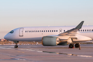 Fototapeta na wymiar Close-up modern white passenger airliner at the airport apron