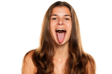 Young woman with her tongue sticking out, isolated on white.