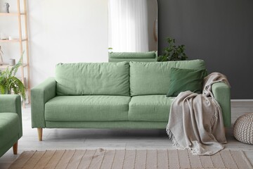 Interior of light living room with green sofa