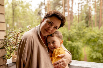 Happy grandmother and grandson enjoy time together. Positive middle age woman spending time with...