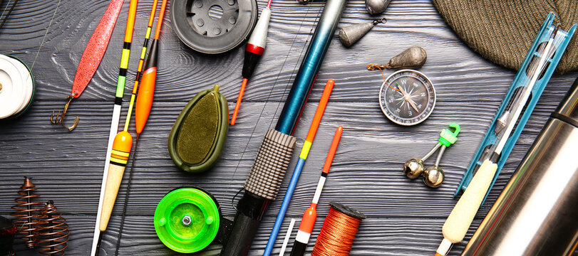 Different fishing equipment on wooden background, top view