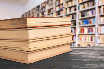 Many books on shelves in modern library, blurred view