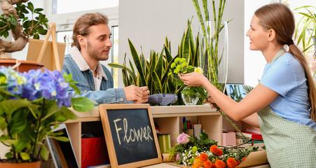 Young man making order in flower shop