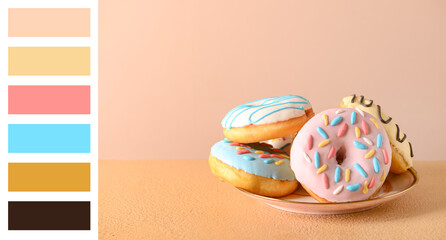 Plate with delicious donuts on table. Different color patterns