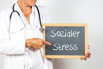 Ärztin zeigt auf eine Tafel auf der sozialer Stress steht