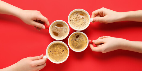 Female hands and cups of coffee on red background, top view