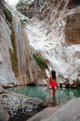 woman in red swimsuit Dimosari waterfall at Lefkada island Greece