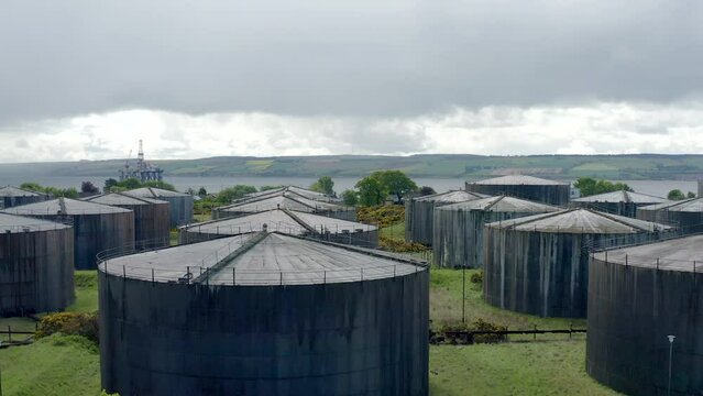 Shoot of Whiskey distillery  in Invergordon - Scotland. Showing sea in background with oil drills in sea.