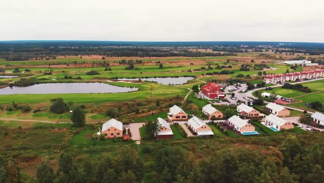 Drone shot of a beautiful peaceful green neighborhood with big houses, ponds, and forest. High quality 4k footage