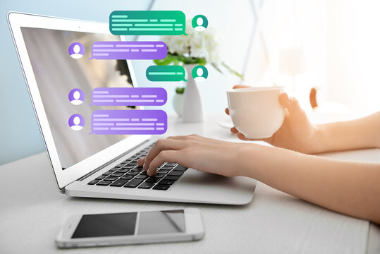 Woman with laptop chatting online at table