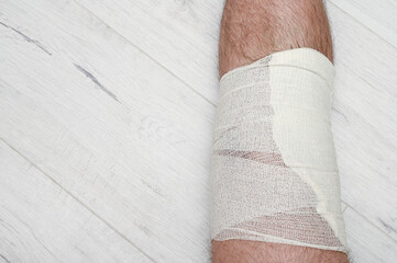 Bandaged leg after knee injury. Elastic self-adhesive bandage.