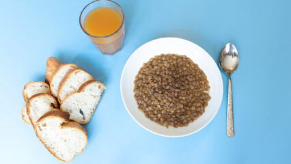fresh food lentil bread rolls and glass of apricot juice on blue table