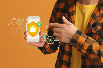 Man with mobile phone on orange background. Antivirus concept