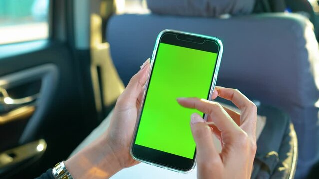 Woman Scrolling and Zooming In On Phone Green Screen Inside Car Daytime Static Over The Shoulder