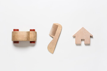 Wooden hair comb and baby toys on white background