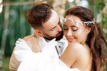 Fototapeta premium Gentle portrait of the bride and groom in the forest. Wedding ceremony