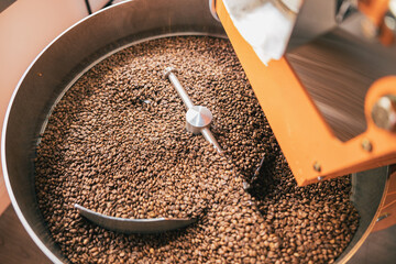 Close up of coffee roasting machine with coffee beans in small coffee manufacturing