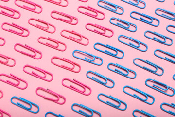 Pink and blue paper clips on color background