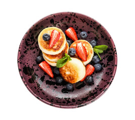 Plate with delicious cottage cheese pancakes, fresh berries and mint leaves on white background