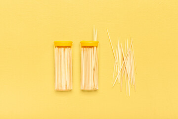 Holders with wooden toothpicks on yellow background