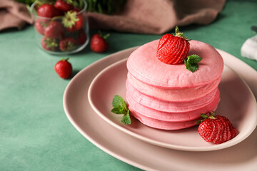 Plate of tasty pink pancakes on color background