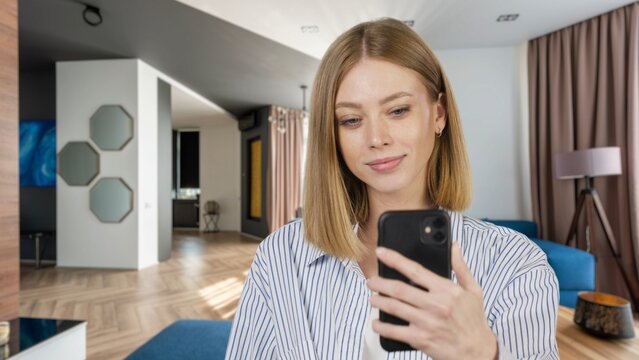 Close-uo of young woman speaking on video call, vlogger using smartphone talking at camera webcam online, selfie call, record lifestyle vlog, blogger online streaming at home 