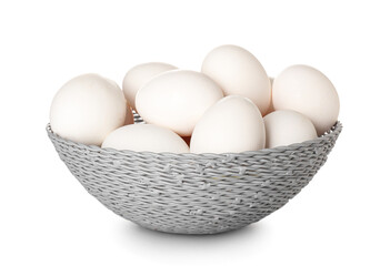 Wicker basket with chicken eggs on white background