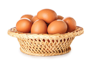 Wicker basket with brown chicken eggs on white background