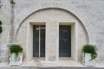 Fototapeta na wymiar Entrance of thebuilding with stone wall and glass doors