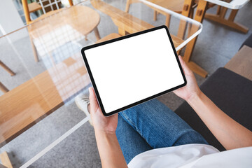 Top view mockup image of a woman holding digital tablet with blank white desktop screen in cafe