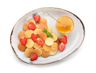 Bowl of tasty mini pancakes, honey and strawberry on white background