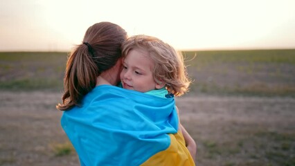 Ukrainian family - loving smiling son hugs mom tightly. Tender scene. Cute 3 year old kid with mother. Peace in Ukraine, future generation, parenthood, childhood, children wellbeing concept.