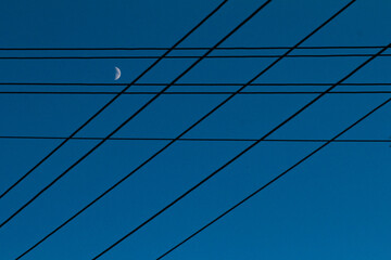 A pattern of electric wires against a blue evening sky