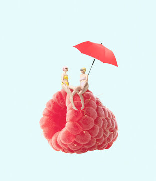 Naklejki Contemporary art collage. Two girls in swimming suit sitting on raspberry under beach umbrella isolated over blue background
