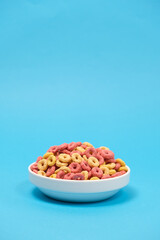 Quick cereal breakfast in the form of rings on a plate on a blue background