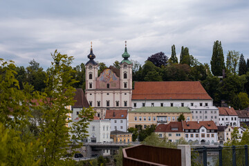 Panorama or cityscape of a church in steyr, austria, rising above the enns river in cloudy weather. Austrian panorama of a city in the steiermark region.