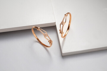 Top view of two golden bracelets on white dramatic background with copy space