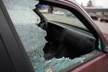 Broken side window in car by burglar to get valuables, robbery or driving accident concept