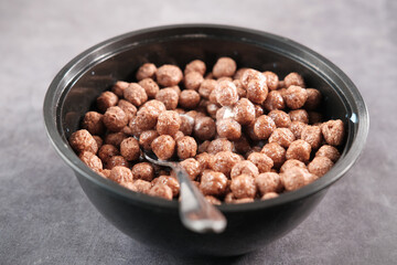 chocolate corn flakes in a bowl on table