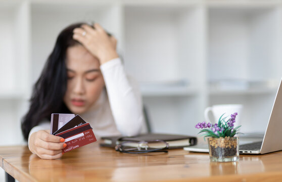 Asian woman worried about overspending and stressed to credit card debt. Concept of financial problems.