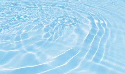 rippled light blue water surface with reflections of sunshine, diagonal top perspective, abstract...