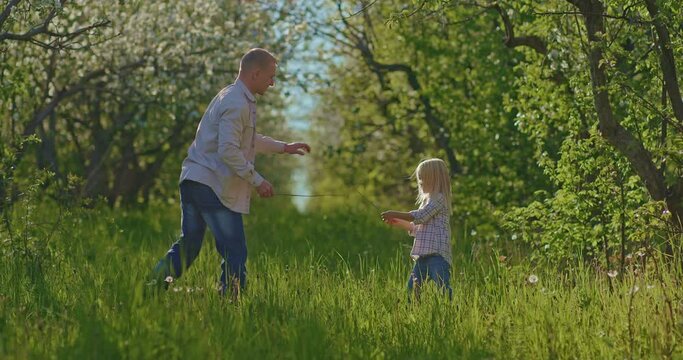 cute little girl and her father are fighting by sticks for fun in beautiful garden, 4K, Prores